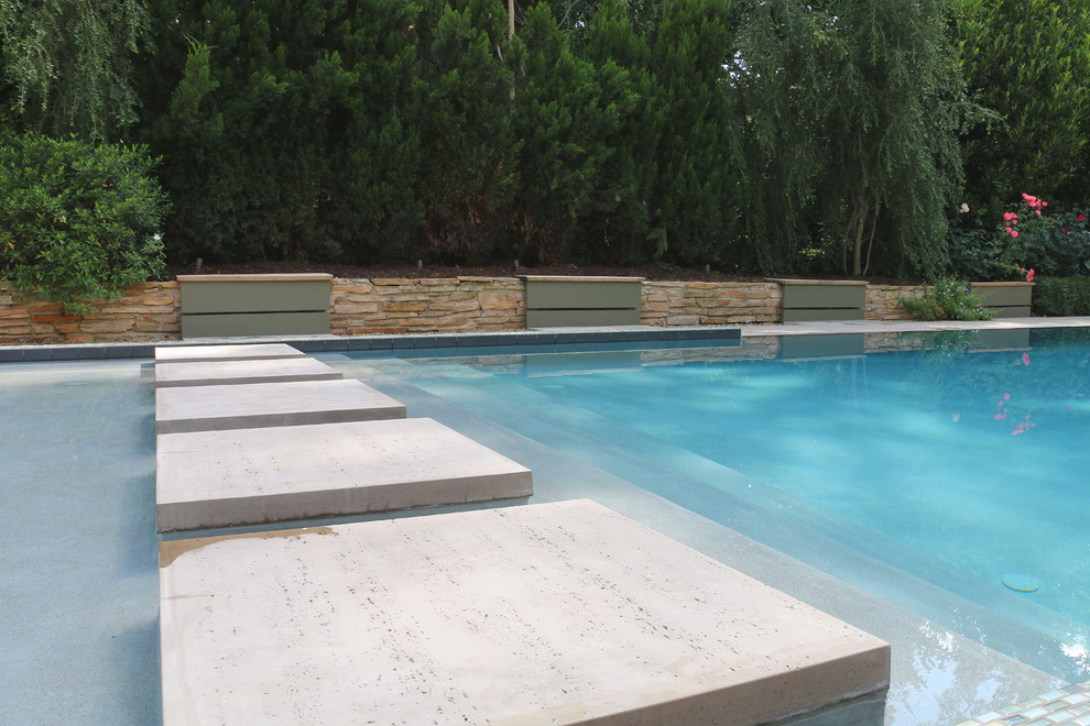 Inspiration for a mid-sized modern courtyard concrete paver and rectangular infinity pool fountain remodel in Raleigh