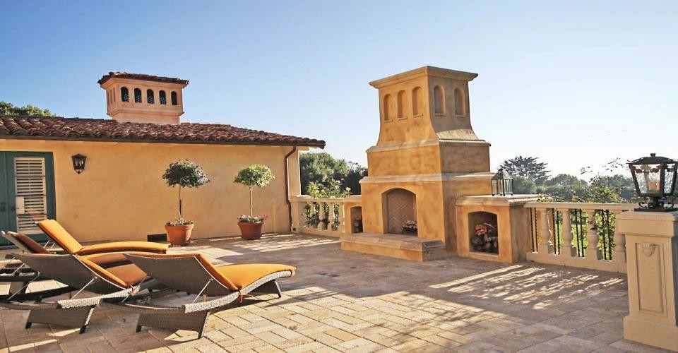 Mediterranean rooftop deck in Santa Barbara with a fire feature and no cover.