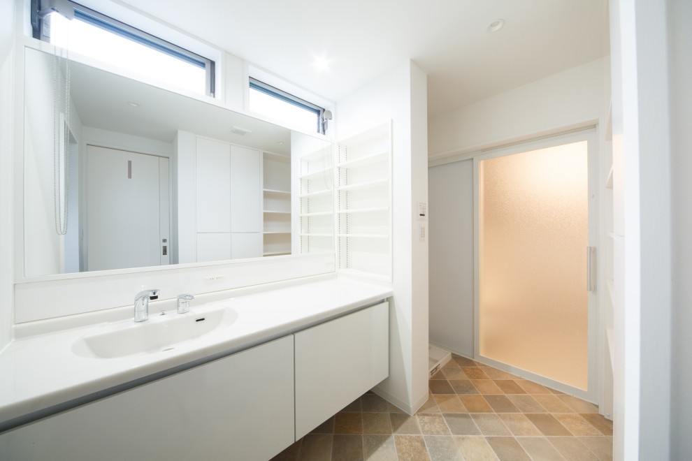 Photo of a mid-sized modern powder room in Kyoto with white walls, linoleum floors, solid surface benchtops, beige floor and white benchtops.