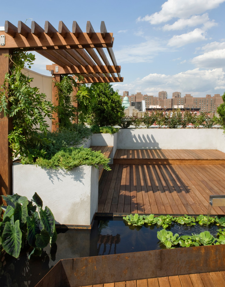 This is an example of a large contemporary rooftop deck in New York with a water feature.
