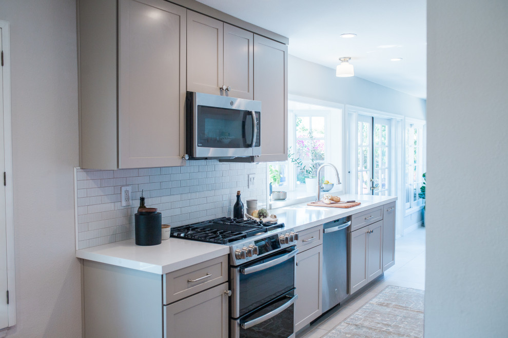Example of a small transitional galley porcelain tile and beige floor open concept kitchen design in Orange County with a double-bowl sink, shaker cabinets, beige cabinets, quartz countertops, white backsplash, subway tile backsplash, stainless steel appliances, no island and white countertops
