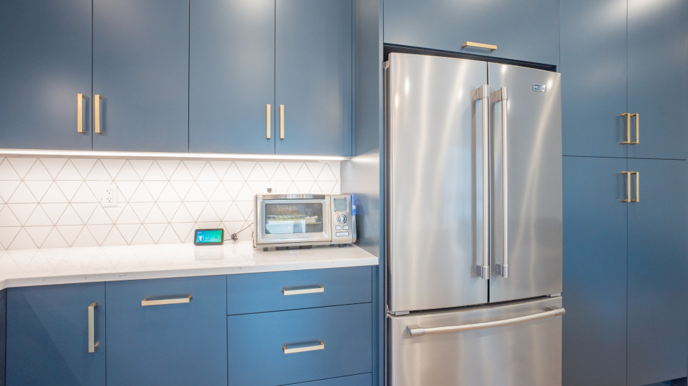 Minimalist l-shaped vinyl floor and beige floor open concept kitchen photo in Toronto with an undermount sink, flat-panel cabinets, blue cabinets, quartz countertops, white backsplash, ceramic backsplash, stainless steel appliances, an island and white countertops