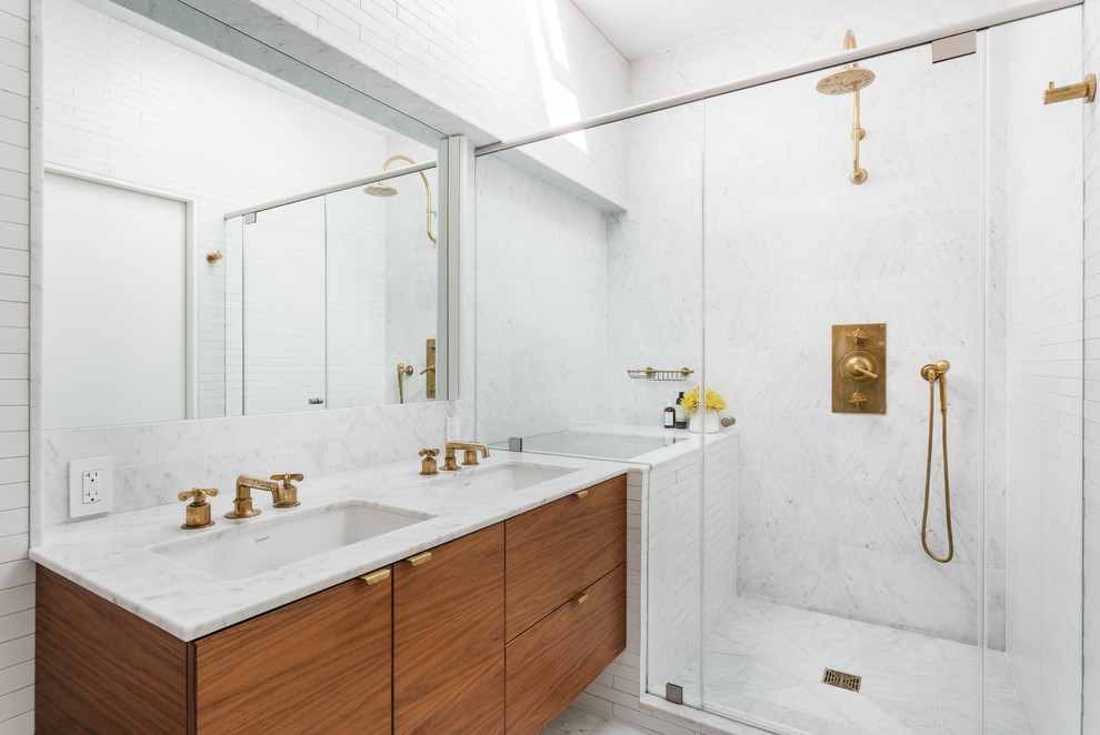 Mid-sized contemporary master wet room bathroom in New York with flat-panel cabinets, medium wood cabinets, white tile, an undermount sink, white floor, a hinged shower door, white benchtops, a wall-mount toilet, marble, white walls, marble floors and marble benchtops.