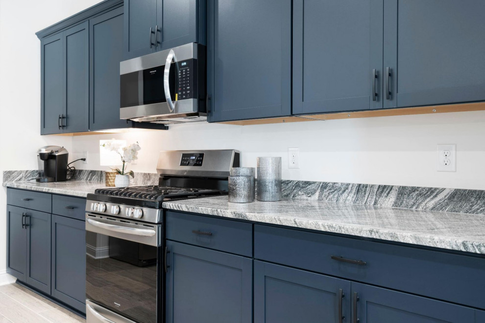 Idee per una cucina classica di medie dimensioni con ante blu, top in granito, elettrodomestici in acciaio inossidabile, pavimento in laminato, pavimento beige e top grigio