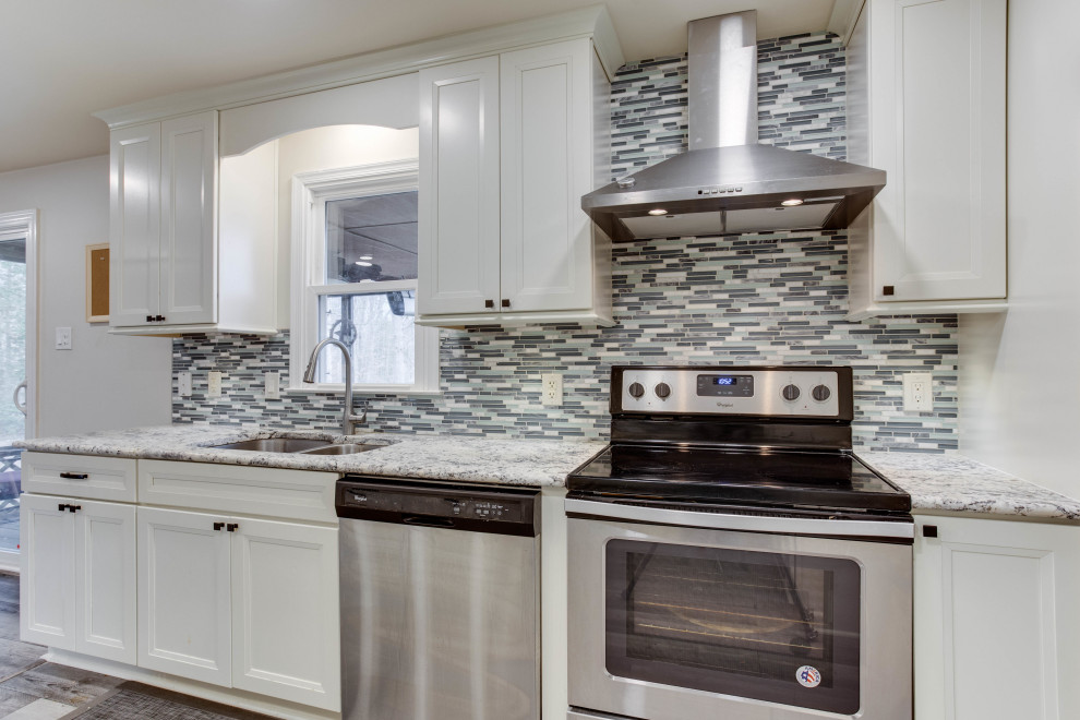 Example of a large transitional u-shaped eat-in kitchen design in DC Metro with an undermount sink, granite countertops, stainless steel appliances and an island