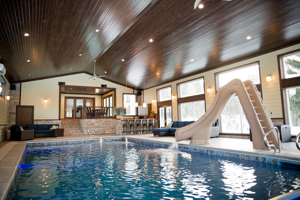 Design ideas for an expansive traditional indoor l-shaped pool in Other with a pool house and tile.