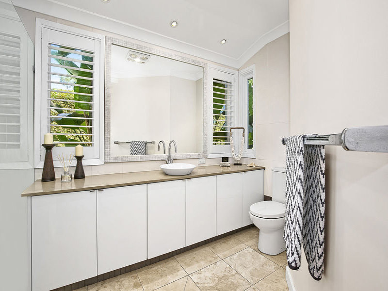 This is an example of a small 3/4 bathroom in Sydney with white cabinets, a double shower, a two-piece toilet, white walls and granite benchtops.