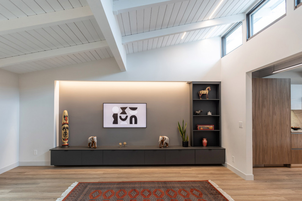 Esempio di un soggiorno moderno di medie dimensioni con pareti grigie, pavimento in laminato, parete attrezzata, pavimento marrone e travi a vista