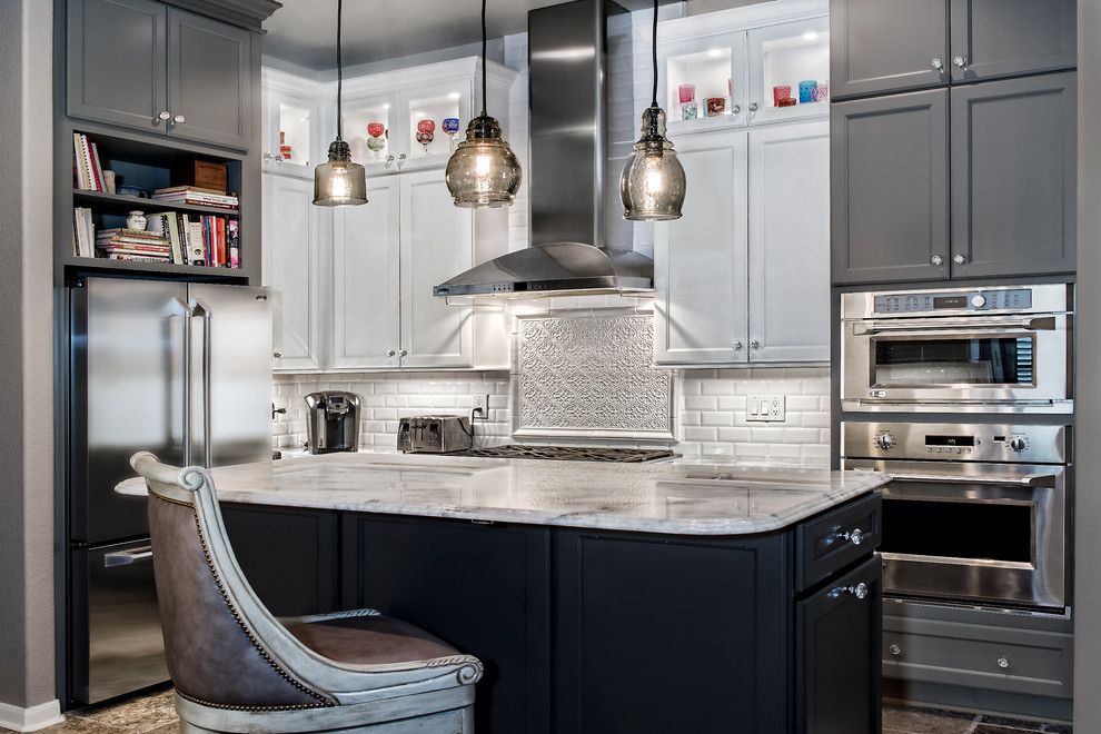 Inspiration for a mid-sized transitional u-shaped eat-in kitchen in Austin with a double-bowl sink, flat-panel cabinets, grey cabinets, granite benchtops, white splashback, subway tile splashback, stainless steel appliances, travertine floors and with island.