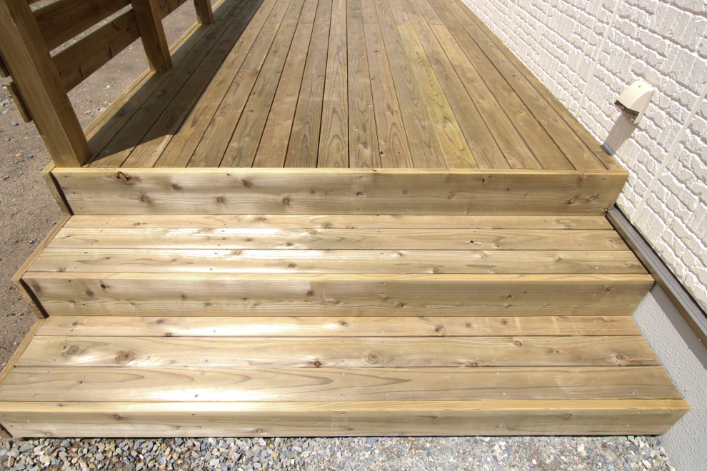 Modelo de terraza planta baja en patio trasero con pérgola y barandilla de madera