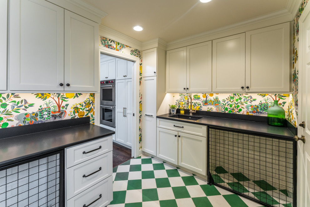 Inspiration for a medium sized traditional l-shaped utility room in Kansas City with a submerged sink, shaker cabinets, white cabinets, engineered stone countertops, multi-coloured walls, a side by side washer and dryer, green floors, black worktops and wallpapered walls.
