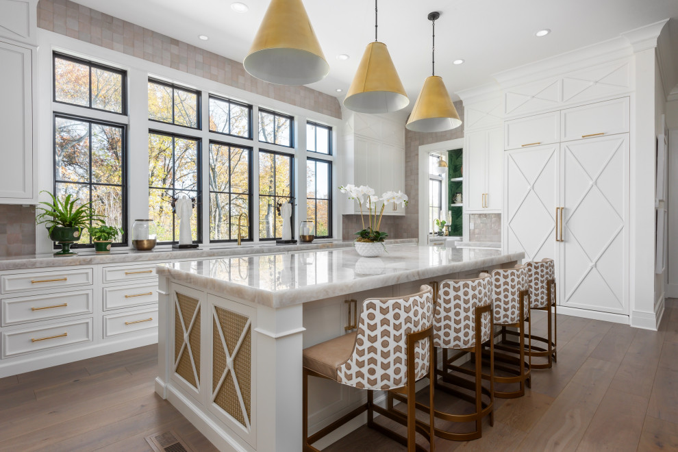 This is an example of an expansive transitional u-shaped open plan kitchen in St Louis with recessed-panel cabinets, white cabinets, quartzite benchtops, panelled appliances, medium hardwood floors, with island and brown floor.