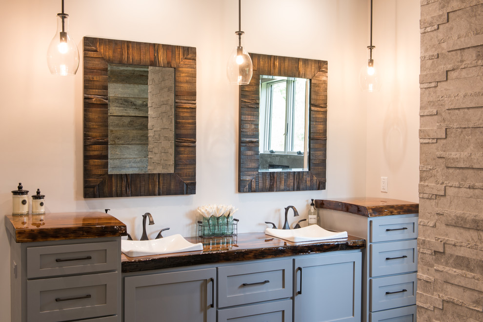 This is an example of a large country master bathroom in Charleston with shaker cabinets, grey cabinets, a freestanding tub, an open shower, beige walls, a drop-in sink, wood benchtops, grey floor, an open shower and brown benchtops.