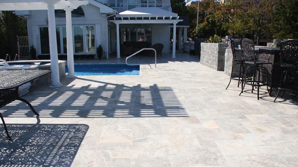 Inspiration for a mid-sized modern backyard custom-shaped natural pool in New York with a pool house and natural stone pavers.