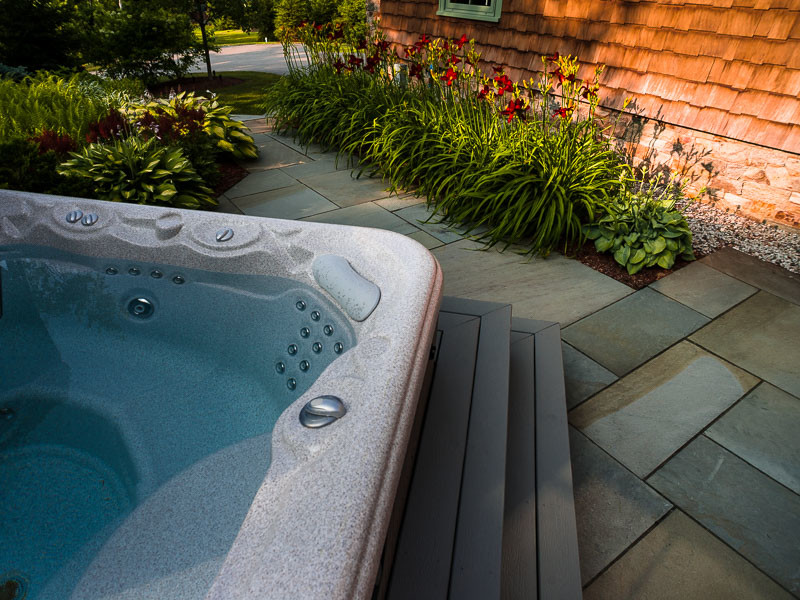 This is an example of a mid-sized traditional side yard patio in Portland Maine with natural stone pavers.