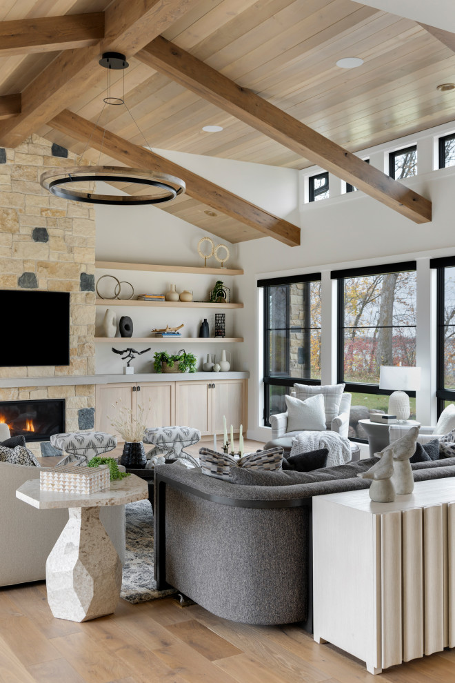 Inspiration for a huge transitional open concept exposed beam and wall paneling living room remodel in Minneapolis with white walls, a standard fireplace, a stacked stone fireplace and a wall-mounted tv