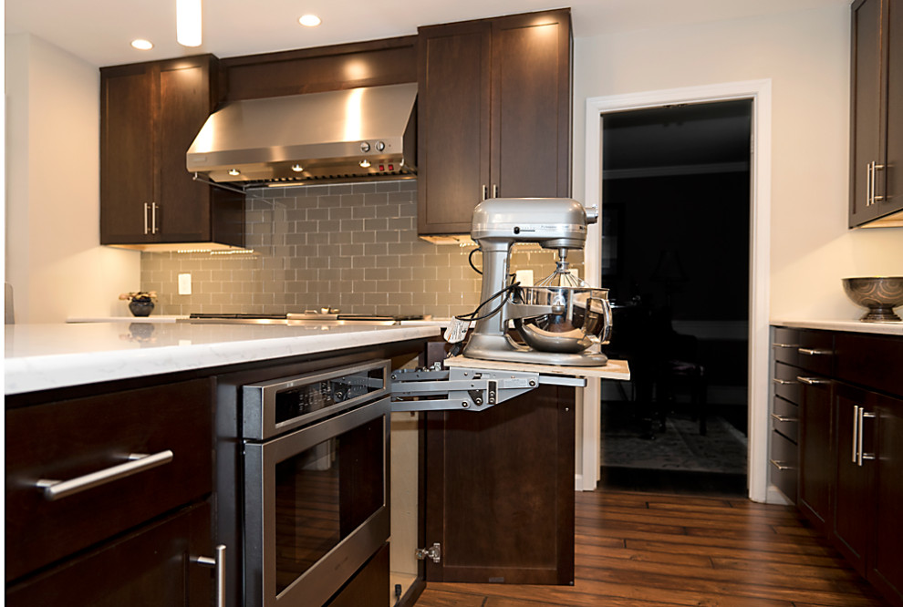 Enclosed kitchen - transitional u-shaped dark wood floor and brown floor enclosed kitchen idea in Baltimore with an undermount sink, shaker cabinets, dark wood cabinets, gray backsplash, subway tile backsplash, stainless steel appliances, an island and white countertops