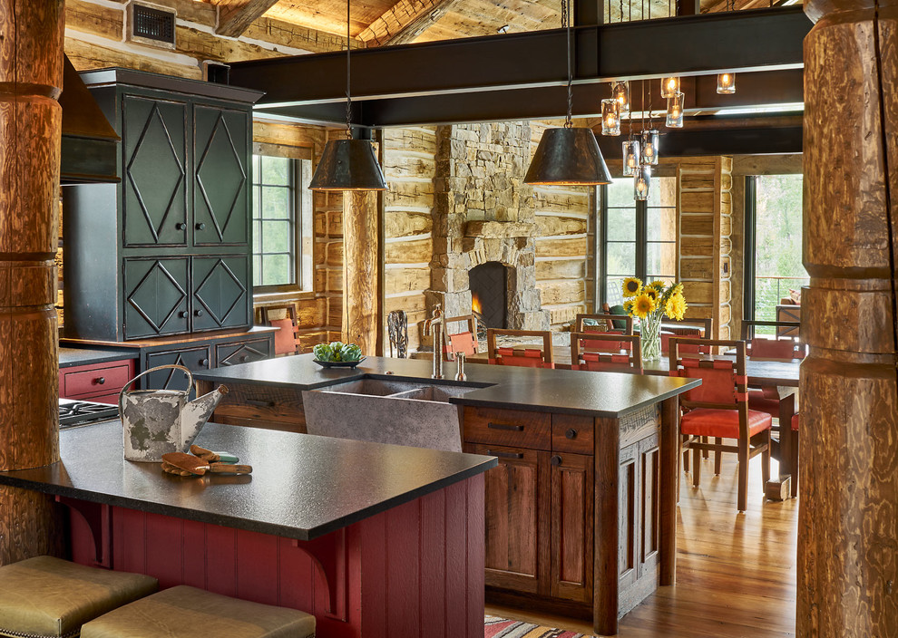 Eclectic open plan kitchen in Denver with a farmhouse sink, raised-panel cabinets, red cabinets, limestone benchtops, timber splashback and multiple islands.