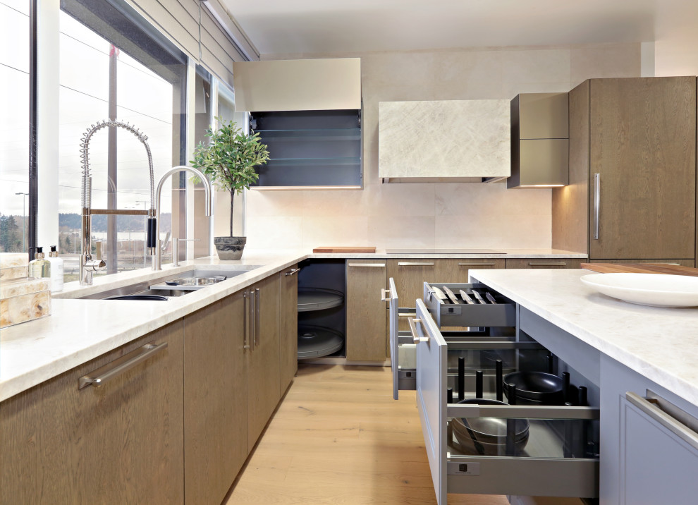Inspiration for a mid-sized transitional l-shaped light wood floor and beige floor open concept kitchen remodel in Seattle with an undermount sink, flat-panel cabinets, gray cabinets, quartzite countertops, beige backsplash, limestone backsplash, stainless steel appliances, an island and beige countertops