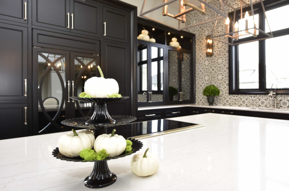 Large transitional l-shaped medium tone wood floor and brown floor eat-in kitchen photo with an undermount sink, recessed-panel cabinets, black cabinets, marble countertops, multicolored backsplash, cement tile backsplash, paneled appliances and an island