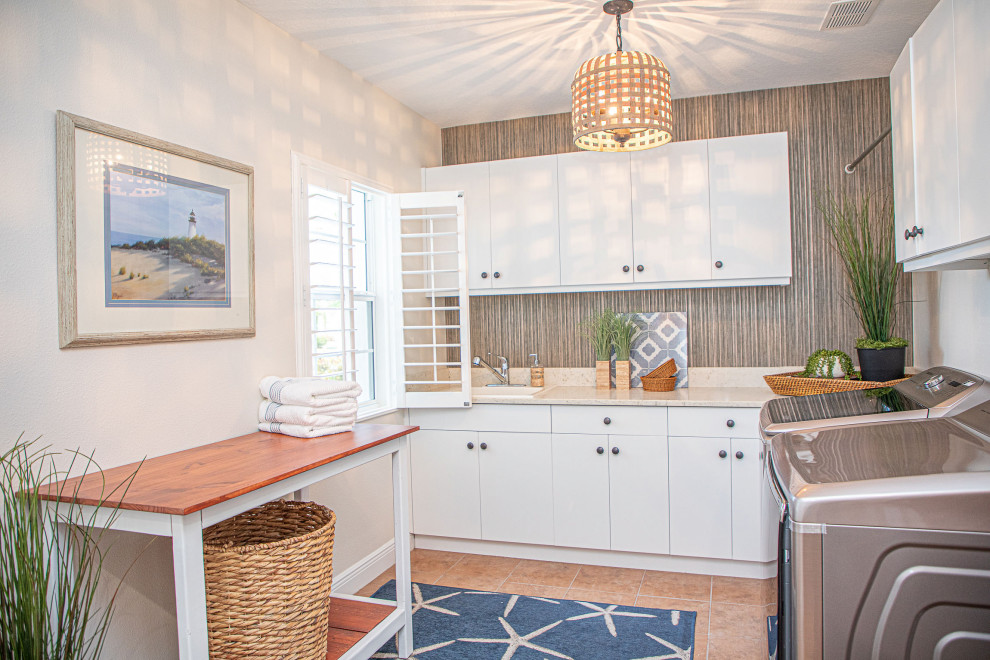 Design ideas for a small beach style l-shaped dedicated laundry room in Tampa with an undermount sink, flat-panel cabinets, white cabinets and a side-by-side washer and dryer.