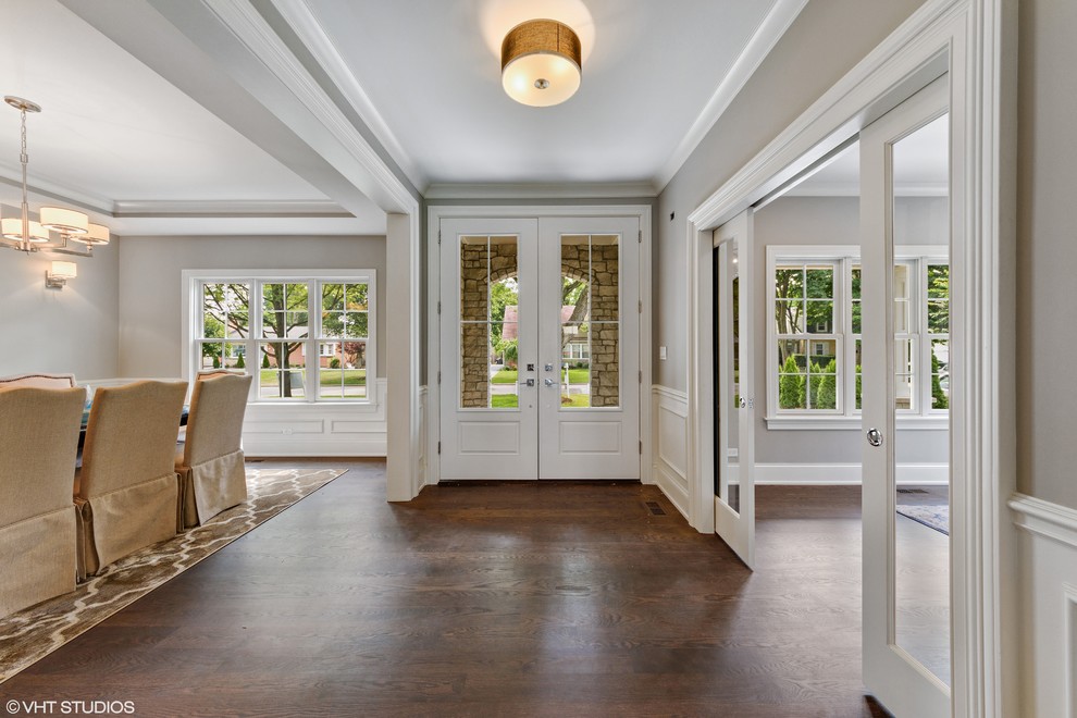Example of a large transitional dark wood floor and brown floor front door design in Chicago with gray walls and a white front door