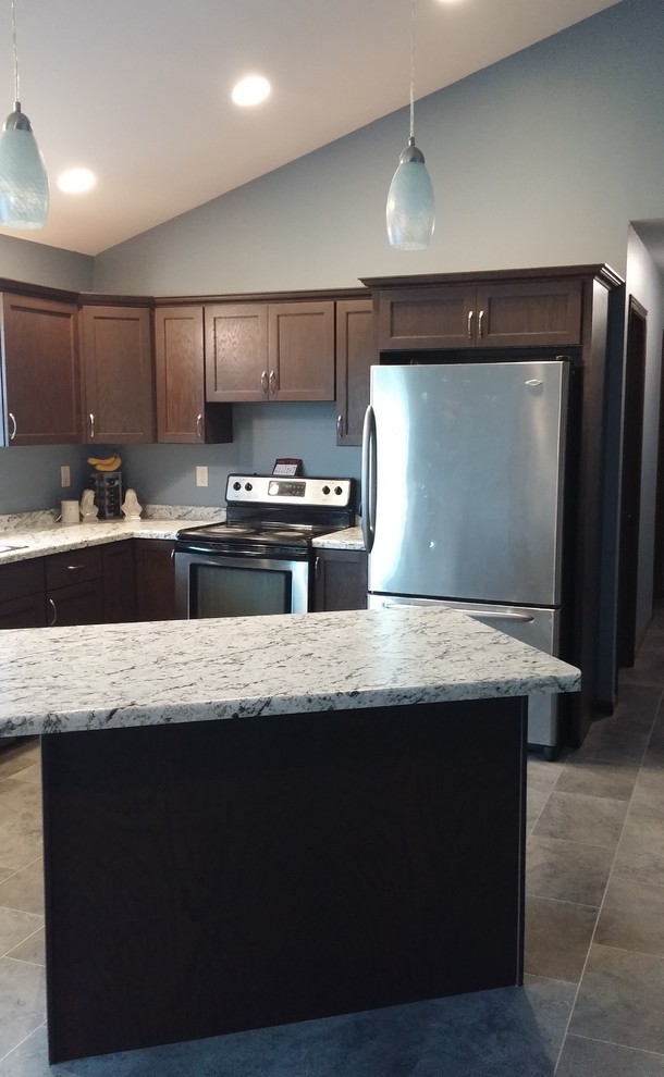 Example of a transitional l-shaped kitchen design with a drop-in sink, shaker cabinets, laminate countertops and an island