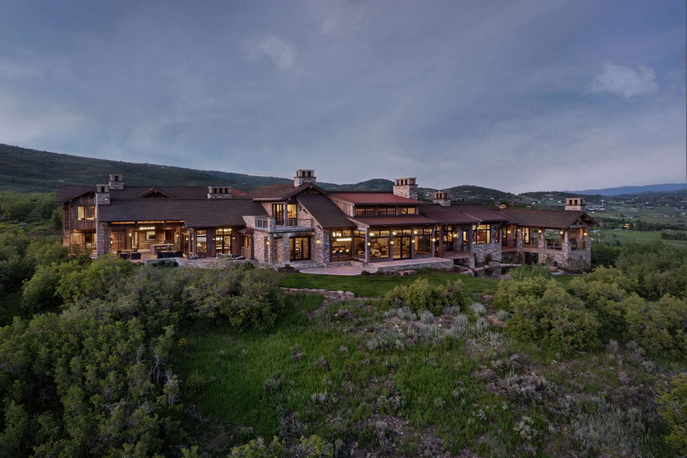 Inspiration for a rustic house exterior remodel with a mixed material roof and a brown roof