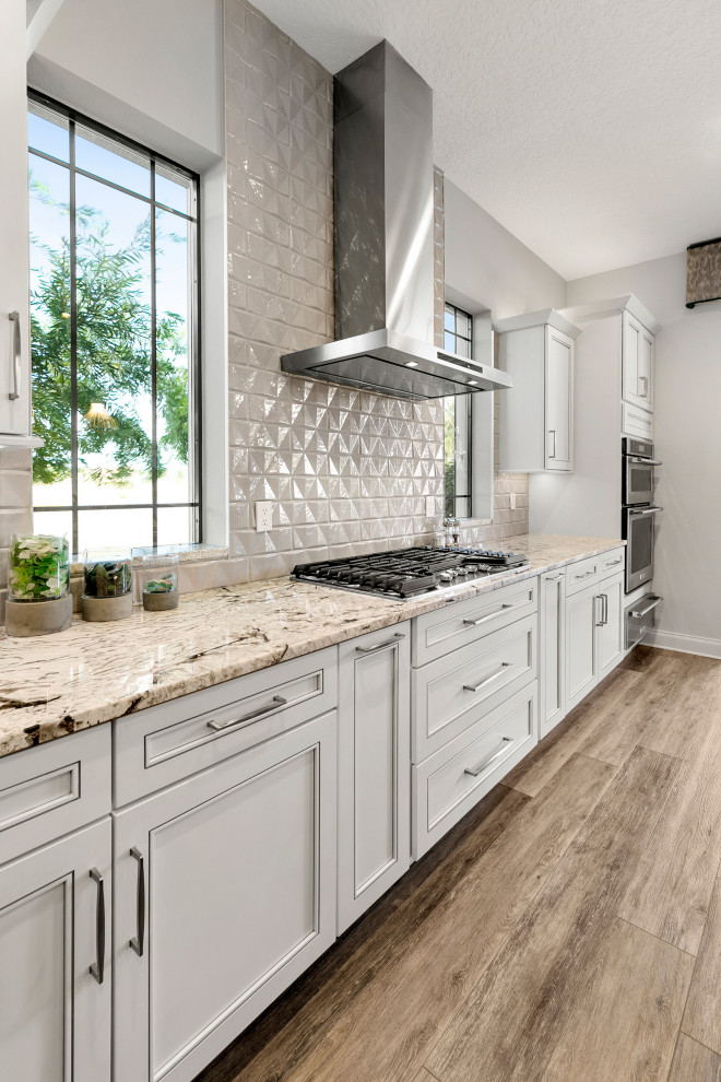 Design ideas for a mid-sized transitional u-shaped eat-in kitchen in Jacksonville with an undermount sink, shaker cabinets, white cabinets, quartzite benchtops, stainless steel appliances, medium hardwood floors, with island, brown floor, beige benchtop and exposed beam.