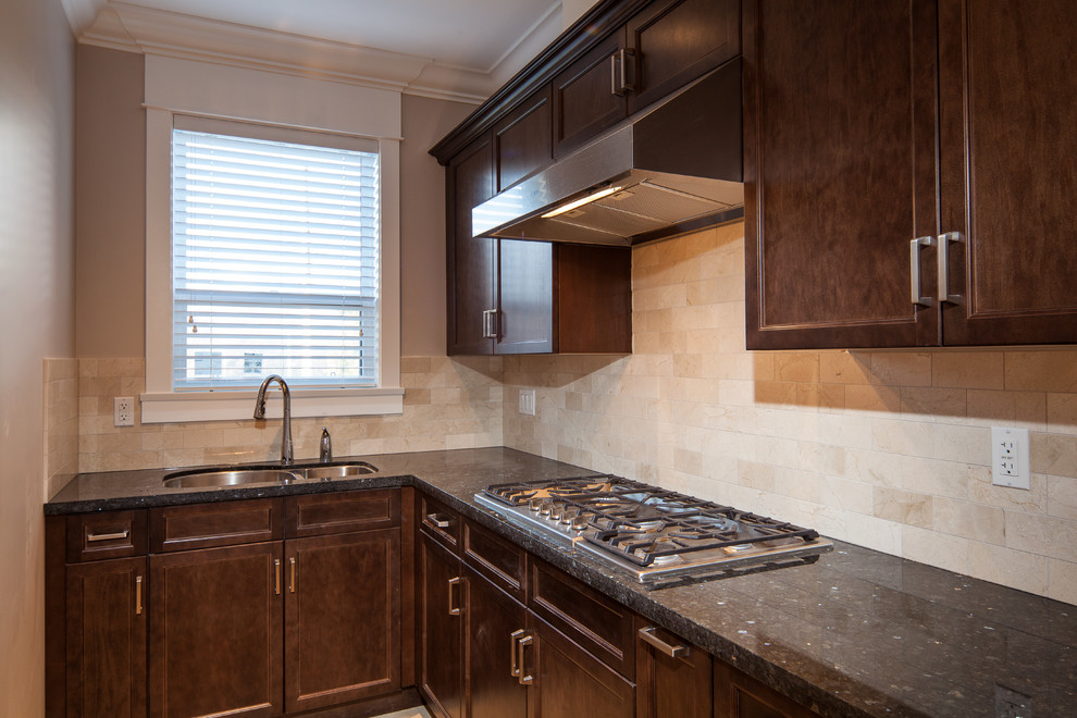 Photo of a transitional l-shaped eat-in kitchen in Vancouver with an undermount sink, recessed-panel cabinets, dark wood cabinets, granite benchtops, beige splashback, stone tile splashback and stainless steel appliances.