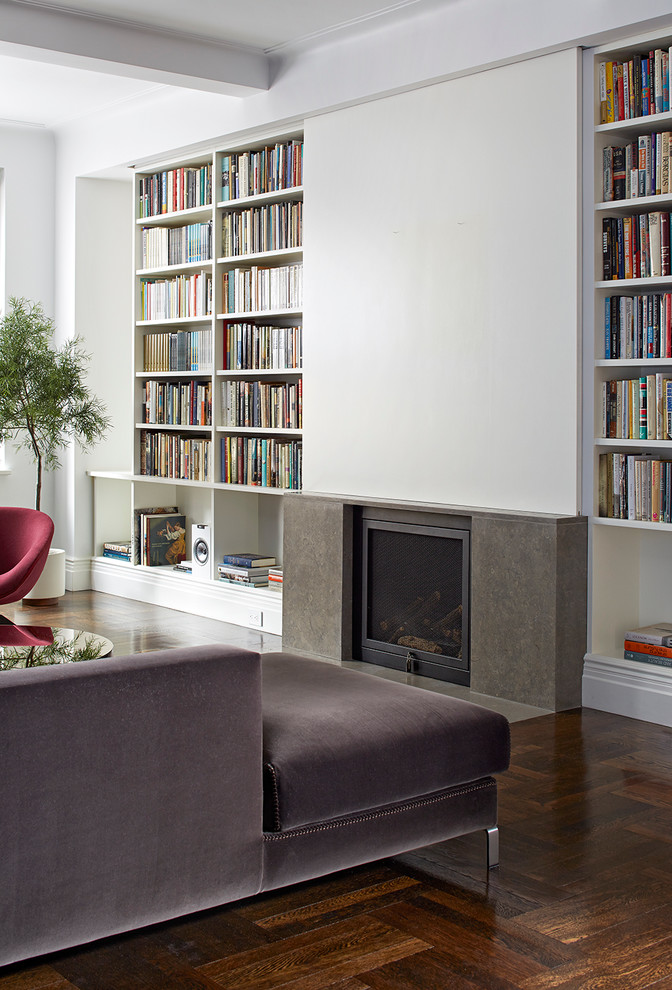 Photo of a mid-sized contemporary open concept living room in New York with white walls, medium hardwood floors, a standard fireplace, a concrete fireplace surround and a concealed tv.