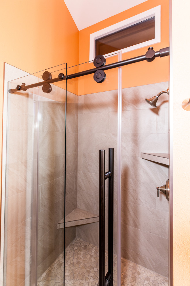 This is an example of a small transitional 3/4 bathroom in Denver with shaker cabinets, dark wood cabinets, an alcove shower, a two-piece toilet, gray tile, porcelain tile, orange walls, porcelain floors, an undermount sink, granite benchtops, grey floor, a sliding shower screen and grey benchtops.