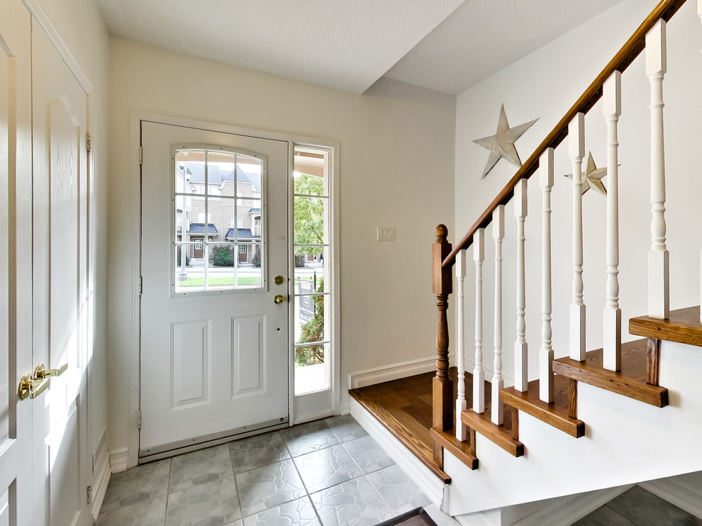 Small transitional ceramic tile and gray floor front door photo in Toronto with white walls and a white front door