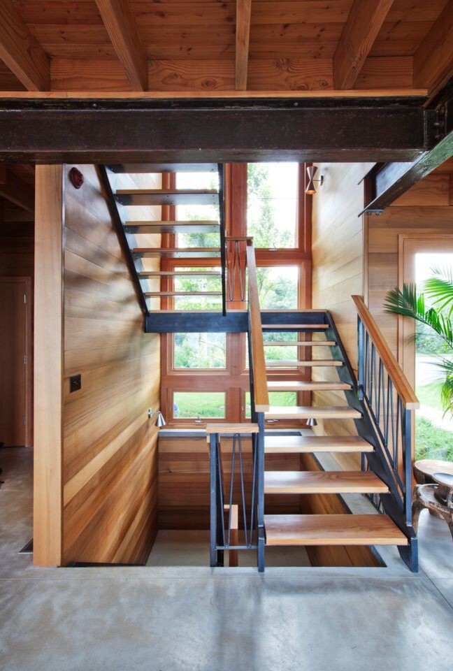 Photo of a large beach style wood u-shaped staircase in Boston with open risers.
