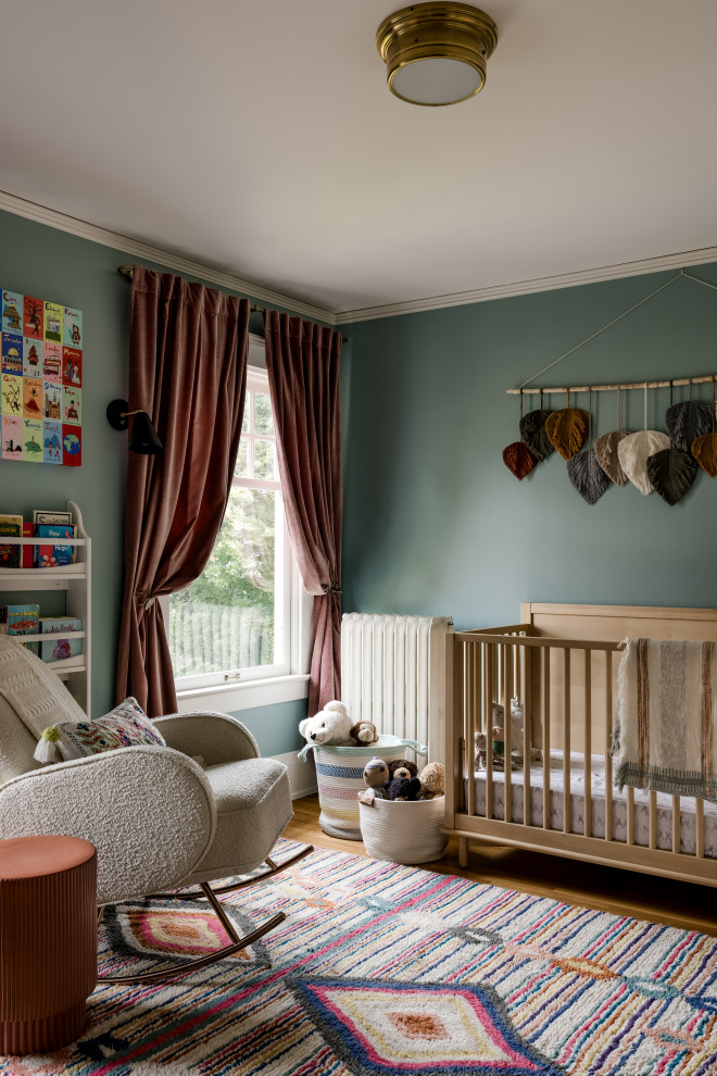 Cette photo montre une chambre de bébé neutre craftsman de taille moyenne avec un mur vert, un sol en bois brun et un sol marron.