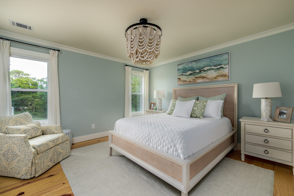 Inspiration for a beach style bedroom in Charleston with blue walls, light hardwood floors and beige floor.