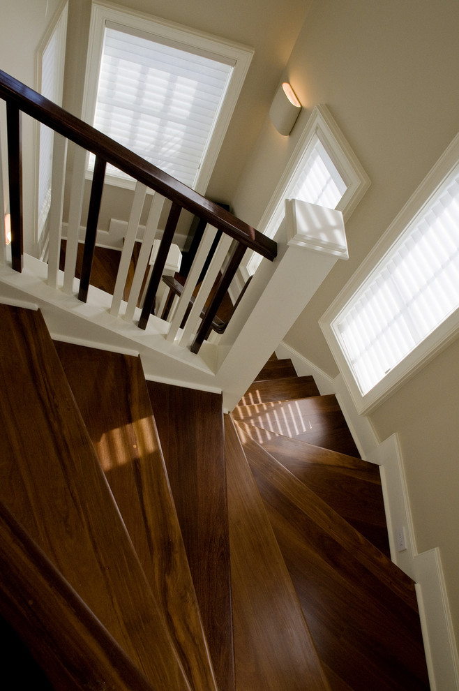 Свежая идея для дизайна: изогнутая деревянная лестница среднего размера в стиле неоклассика (современная классика) с деревянными ступенями и деревянными перилами - отличное фото интерьера