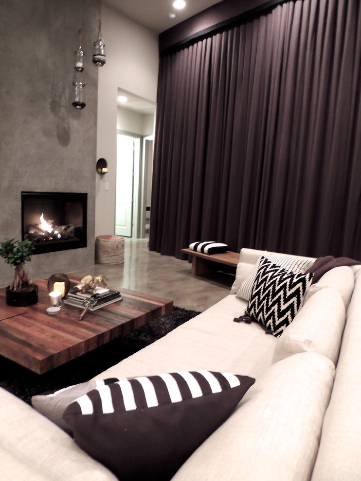 This is an example of a large modern living room in Austin with a built-in media wall, beige walls and concrete floors.