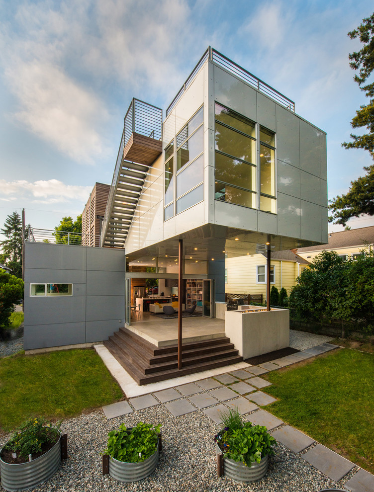 This is an example of a contemporary two-storey exterior in Seattle with a flat roof and mixed siding.