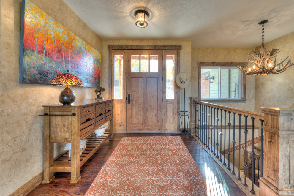 Mountain style medium tone wood floor foyer photo with beige walls and a medium wood front door