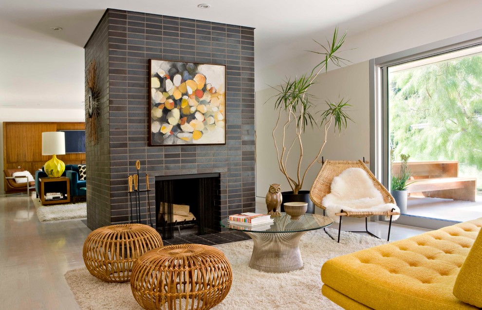 Photo of a midcentury open concept living room in Los Angeles with white walls, a standard fireplace and a tile fireplace surround.