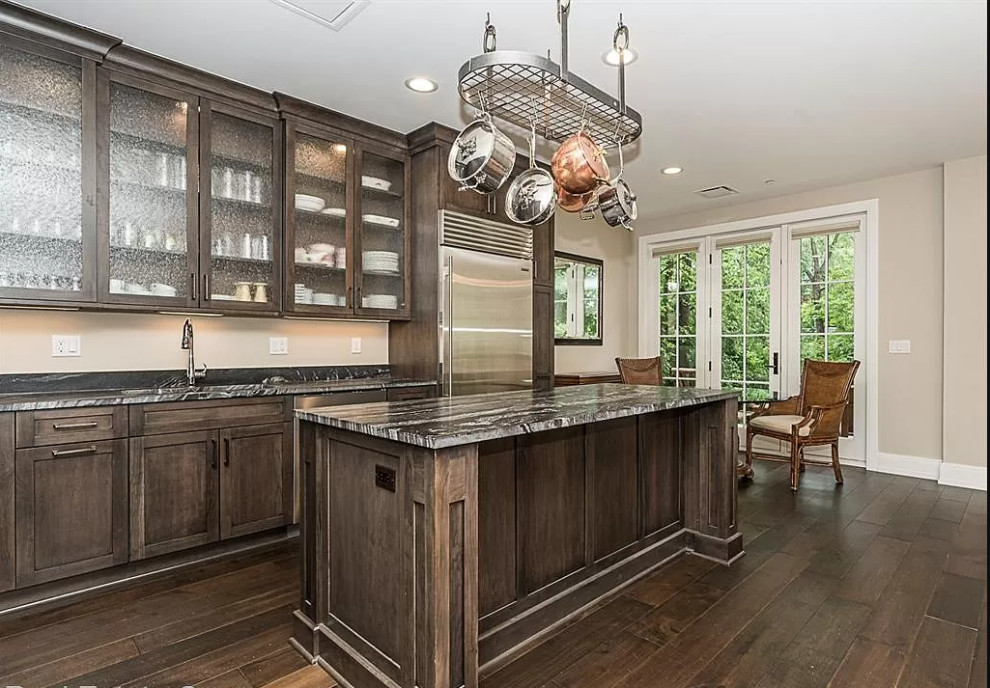Open concept kitchen - mid-sized transitional l-shaped dark wood floor and brown floor open concept kitchen idea in Detroit with an undermount sink, flat-panel cabinets, dark wood cabinets, granite countertops, gray backsplash, granite backsplash, stainless steel appliances, an island and gray countertops