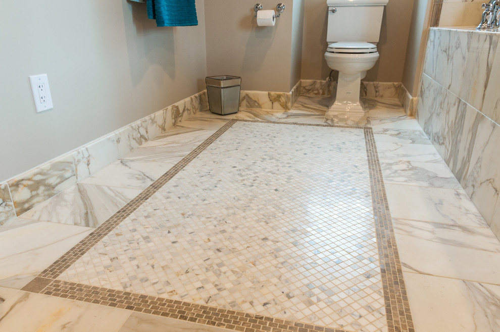 Photo of a large traditional master bathroom in DC Metro with recessed-panel cabinets, beige cabinets, a drop-in tub, an alcove shower, a one-piece toilet, multi-coloured tile, mosaic tile, beige walls, marble floors, an undermount sink and marble benchtops.