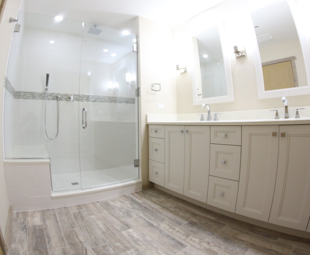 Alcove shower - mid-sized rustic master ceramic tile porcelain tile alcove shower idea in Chicago with recessed-panel cabinets, white cabinets, a two-piece toilet, beige walls, an undermount sink and quartz countertops