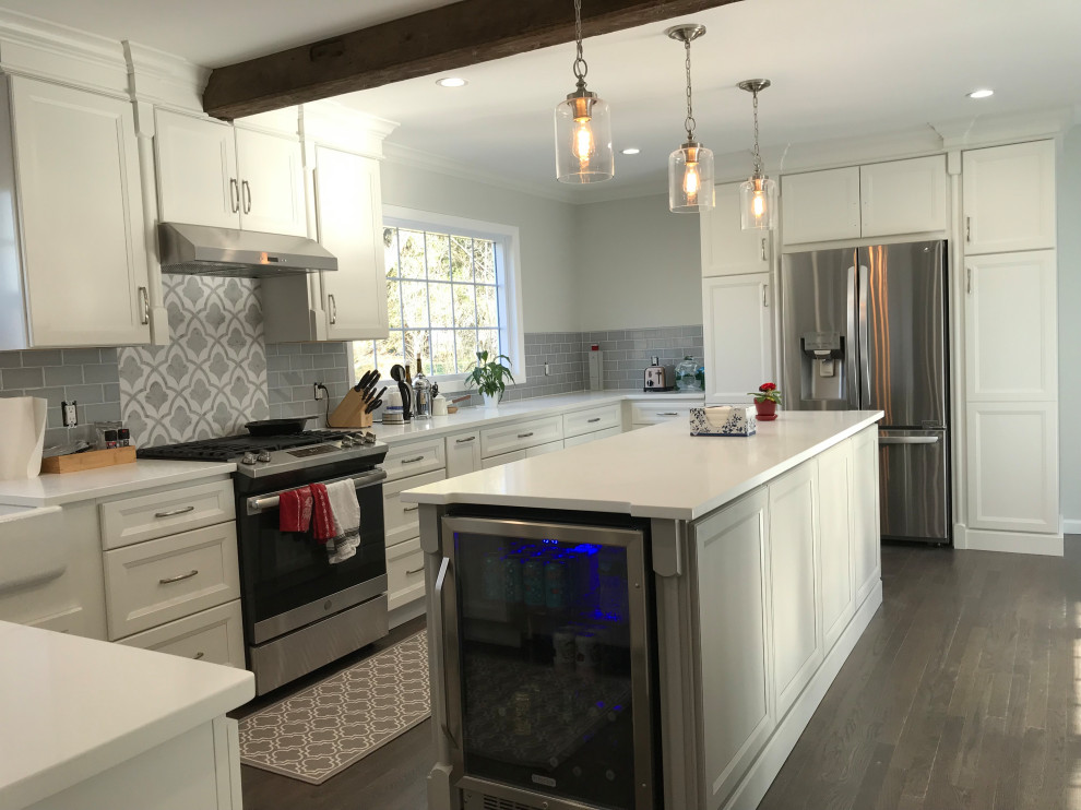 Example of a large transitional u-shaped ceramic tile and gray floor eat-in kitchen design with a farmhouse sink, recessed-panel cabinets, white cabinets, quartz countertops, gray backsplash, subway tile backsplash, stainless steel appliances, an island and white countertops