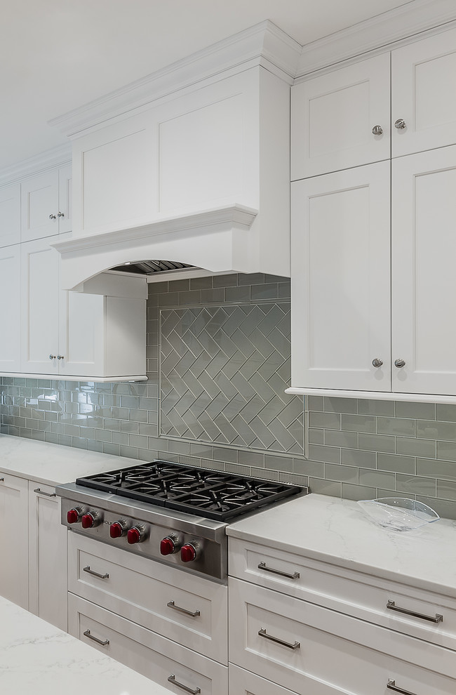 Example of a transitional u-shaped eat-in kitchen design in Providence with an undermount sink, white cabinets, quartzite countertops, glass tile backsplash, stainless steel appliances and an island