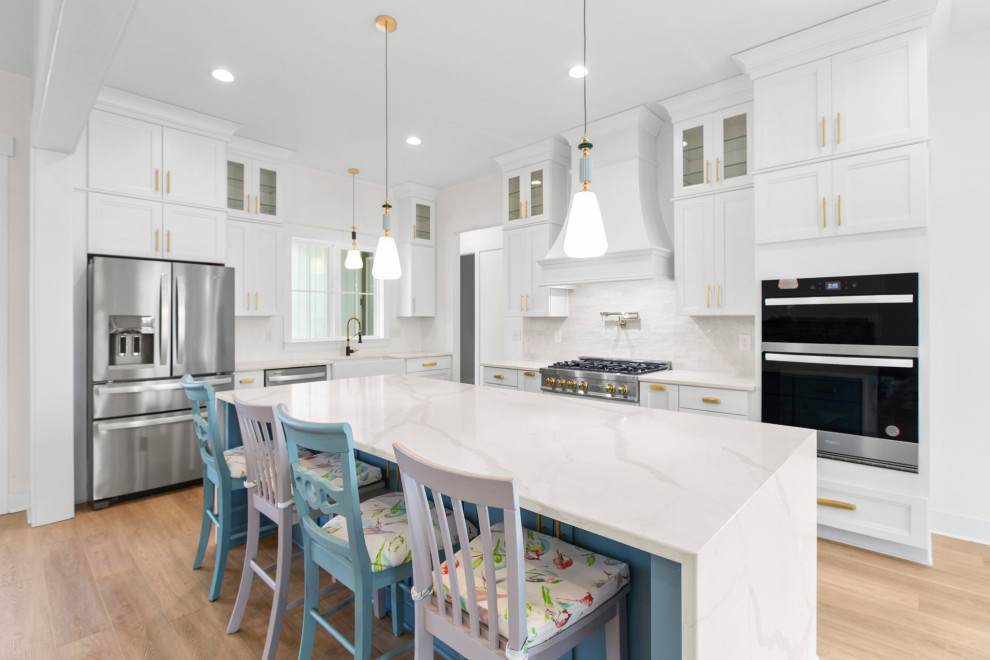 Inspiration for a large transitional l-shaped open concept kitchen remodel in Richmond with a farmhouse sink, recessed-panel cabinets, quartz countertops, white backsplash, stainless steel appliances, an island and white countertops