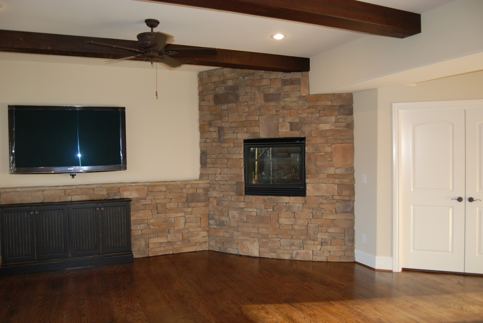 This is an example of a traditional basement in Charlotte with a corner fireplace.