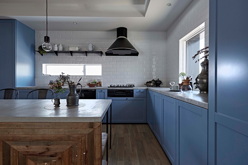 Design ideas for a scandinavian l-shaped eat-in kitchen in Nagoya with blue cabinets, grey benchtop, recessed-panel cabinets, white splashback, painted wood floors, a peninsula and grey floor.