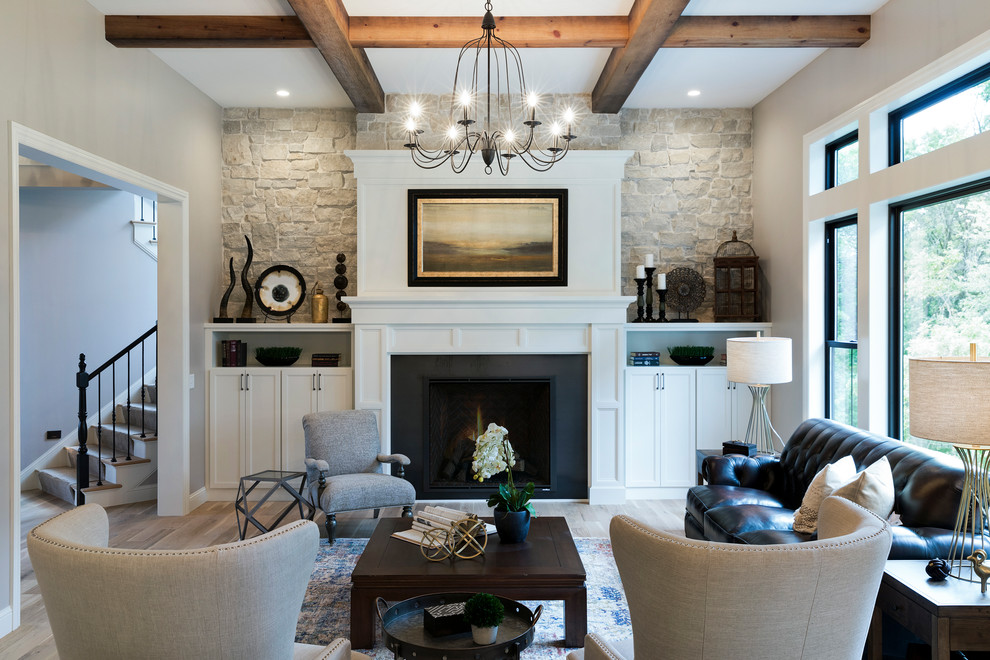 Traditional open concept living room in Minneapolis with grey walls, light hardwood floors and a standard fireplace.